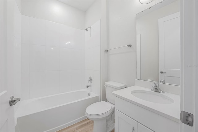 full bathroom featuring tiled shower / bath combo, wood-type flooring, vanity, and toilet