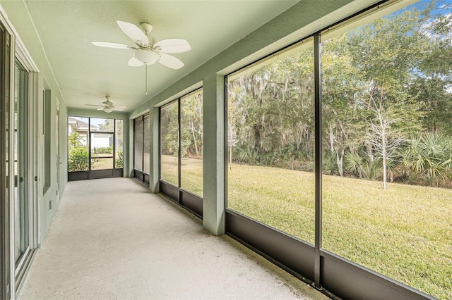 unfurnished sunroom featuring ceiling fan