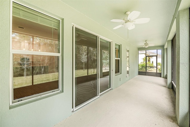 unfurnished sunroom with ceiling fan