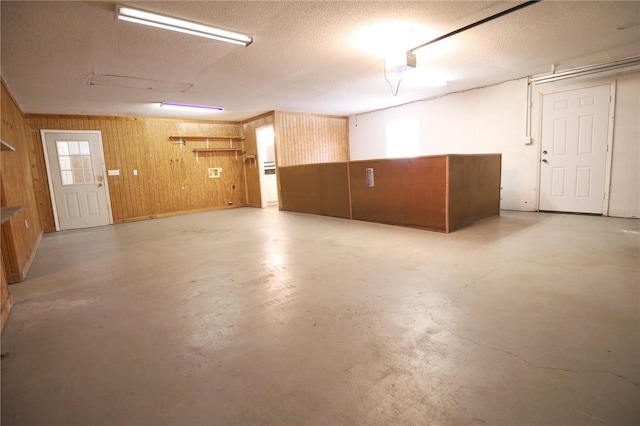 garage with a garage door opener and wood walls