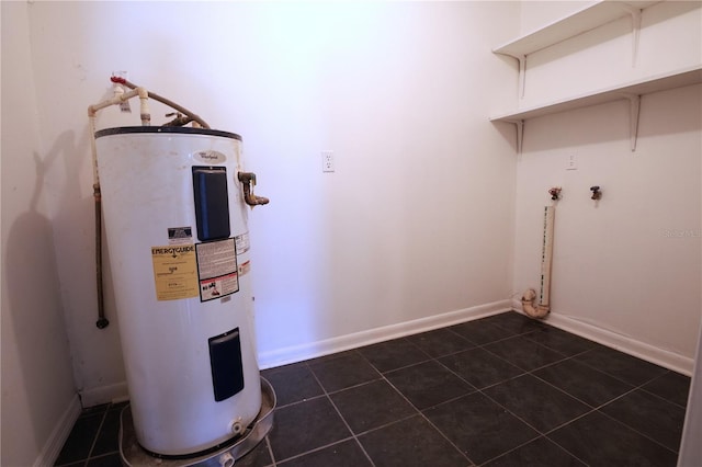 laundry room with dark tile patterned floors and electric water heater