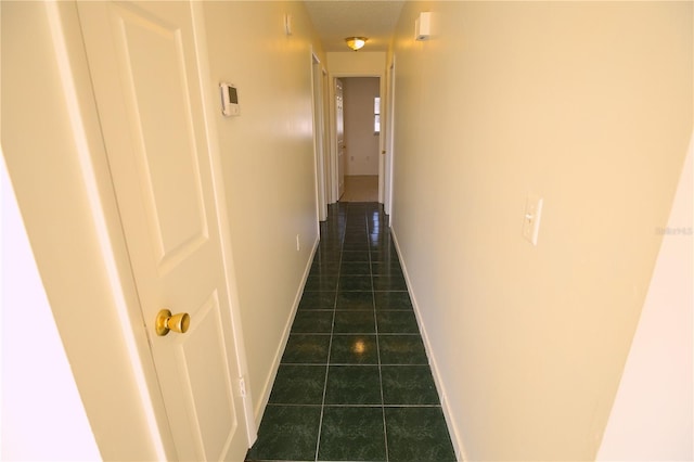 hall featuring dark tile patterned floors