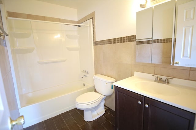 full bathroom with toilet, tile walls, vanity, and shower / bathing tub combination