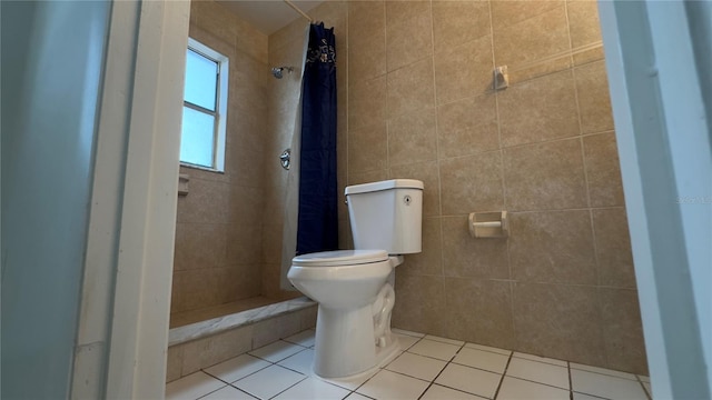 bathroom with tile walls, tile patterned floors, curtained shower, and toilet