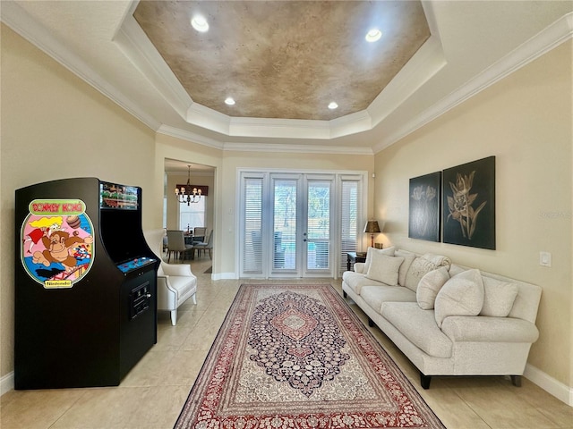 tiled living room with ornamental molding, a raised ceiling, and a chandelier