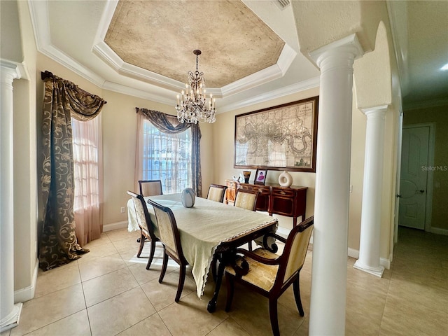 dining room featuring light tile patterned floors, an inviting chandelier, a tray ceiling, ornamental molding, and ornate columns