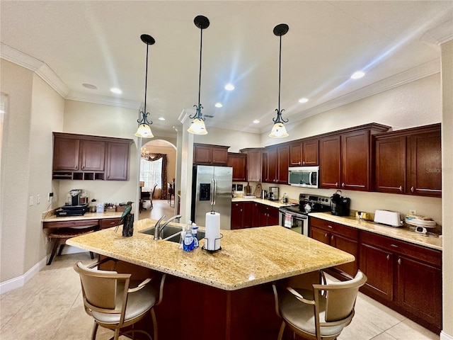 kitchen with stainless steel appliances, an island with sink, crown molding, and decorative light fixtures