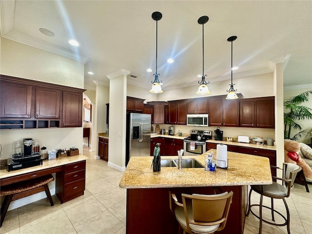 kitchen with appliances with stainless steel finishes, hanging light fixtures, ornamental molding, light stone counters, and a center island with sink