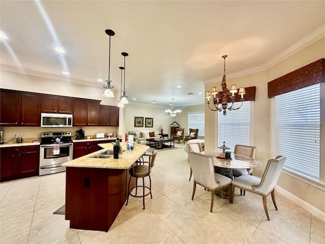 kitchen featuring a breakfast bar, sink, crown molding, a center island with sink, and appliances with stainless steel finishes