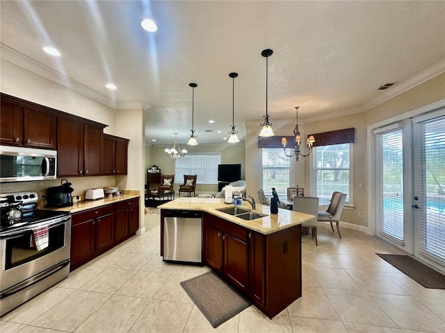 kitchen with an island with sink, sink, hanging light fixtures, a notable chandelier, and stainless steel appliances