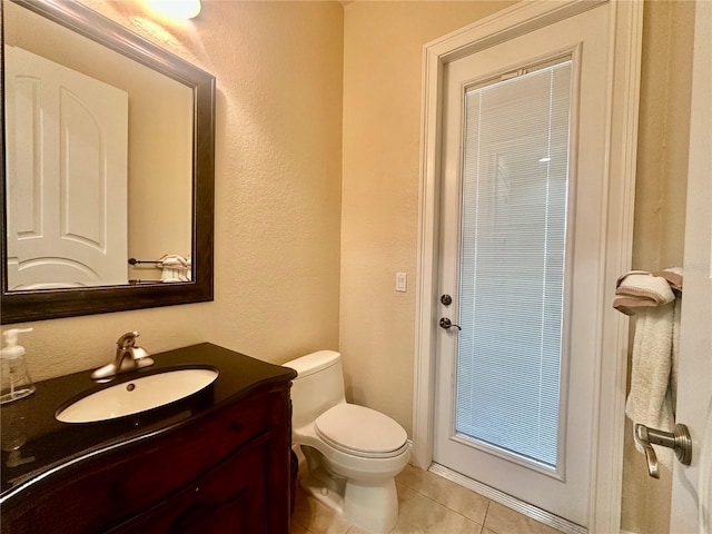 bathroom with tile patterned flooring, vanity, and toilet