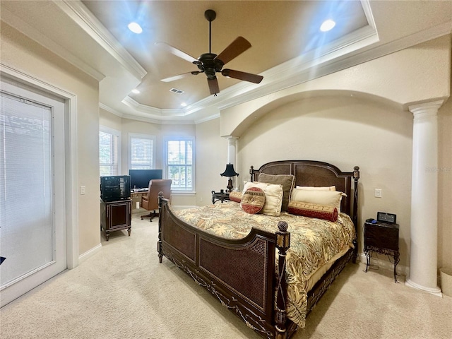 carpeted bedroom with ornamental molding, a raised ceiling, ceiling fan, and ornate columns