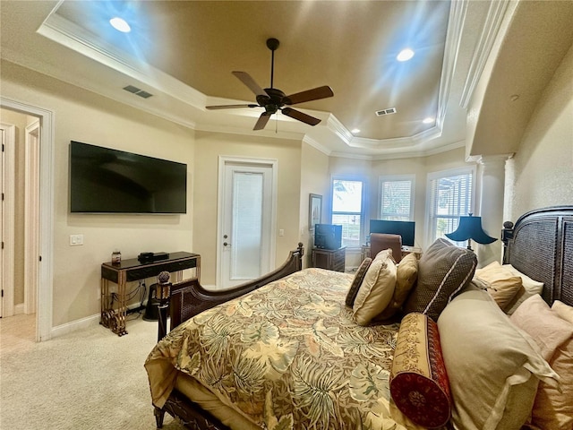 carpeted bedroom featuring crown molding, a tray ceiling, ceiling fan, and ornate columns