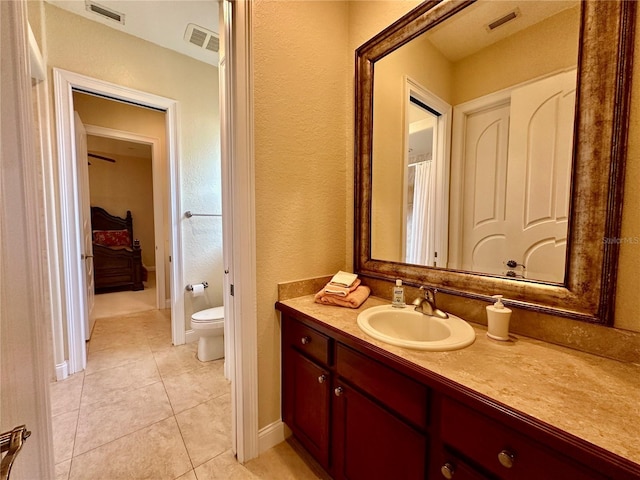 bathroom with tile patterned flooring, vanity, and toilet