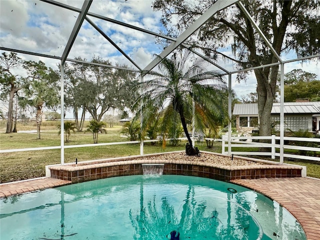 view of swimming pool featuring a lanai, a lawn, and pool water feature