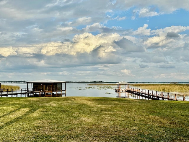 dock area featuring a lawn and a water view