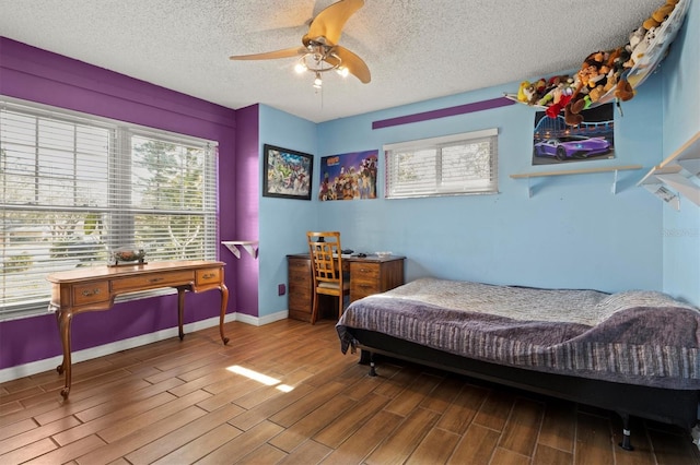 bedroom with hardwood / wood-style floors, a textured ceiling, and ceiling fan