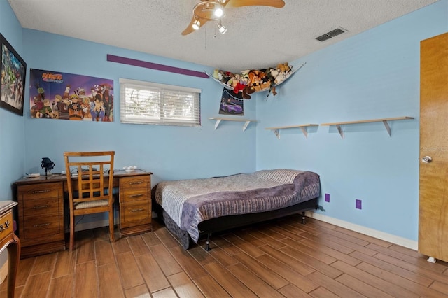 bedroom with wood-type flooring, ceiling fan, and a textured ceiling