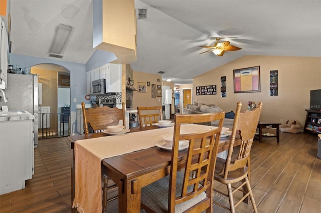 dining space with ceiling fan, lofted ceiling, and a textured ceiling