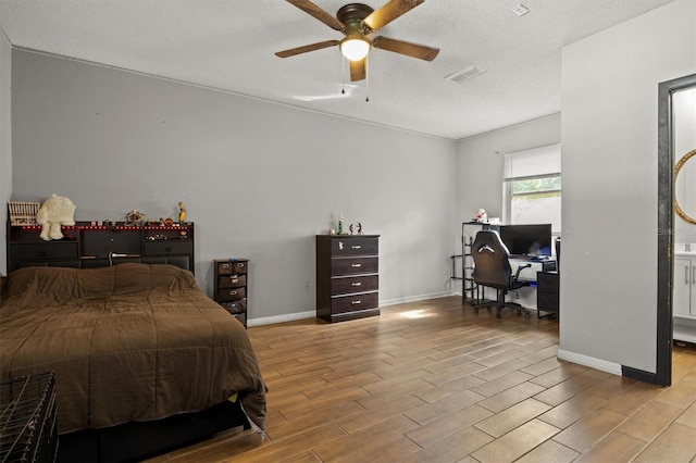 bedroom with ceiling fan, a textured ceiling, and light wood-type flooring