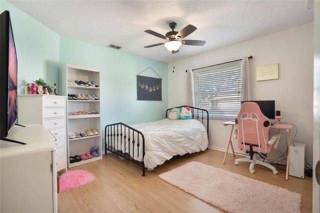 bedroom featuring ceiling fan, a textured ceiling, and light wood-type flooring