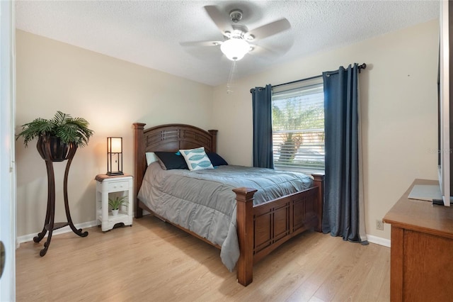 bedroom featuring ceiling fan, a textured ceiling, and light hardwood / wood-style flooring