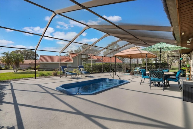 view of swimming pool featuring a patio and glass enclosure