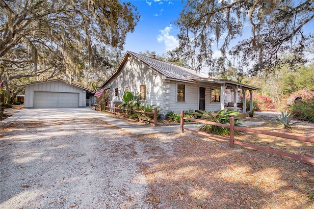 view of front of home featuring a garage, an outbuilding, and metal roof