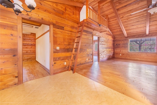 unfurnished room with wooden ceiling, wooden walls, vaulted ceiling with beams, and wood finished floors