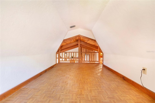 bonus room featuring visible vents, baseboards, a textured ceiling, and vaulted ceiling