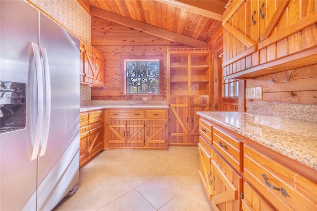 kitchen featuring wooden walls, lofted ceiling, light tile patterned flooring, wood ceiling, and stainless steel refrigerator with ice dispenser