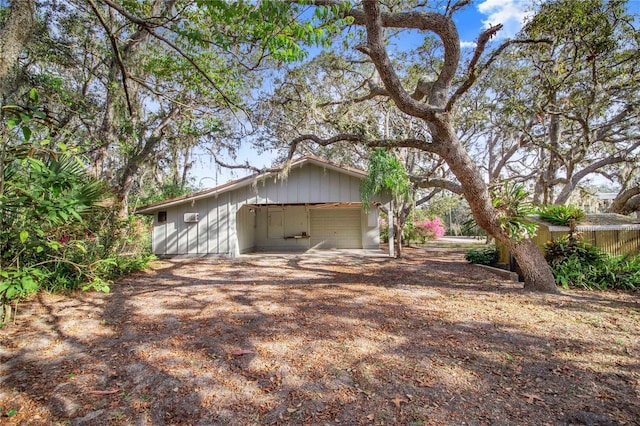 view of side of property featuring a garage and dirt driveway