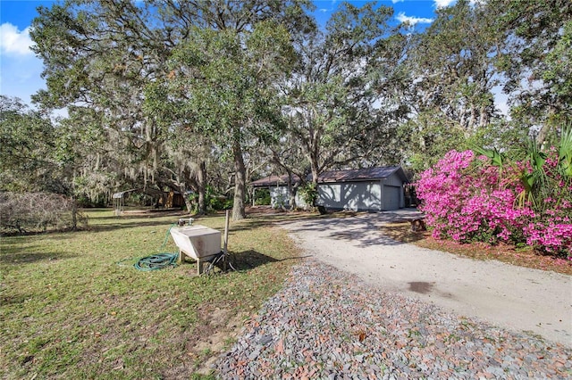 view of yard featuring an outdoor structure and dirt driveway