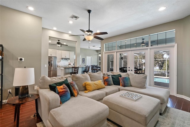 living room with wood-type flooring, a textured ceiling, and french doors