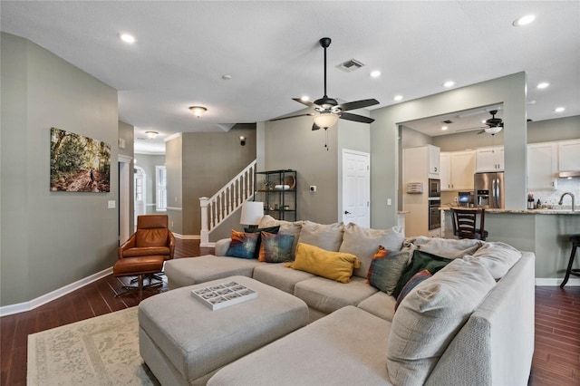 living room featuring ceiling fan, dark hardwood / wood-style floors, and sink