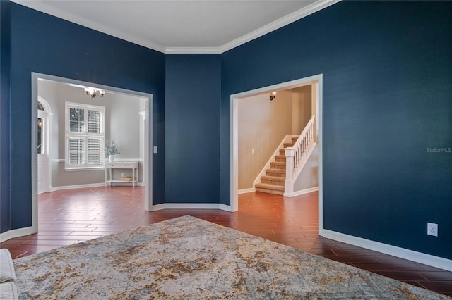 unfurnished room featuring dark hardwood / wood-style flooring, ornamental molding, and an inviting chandelier