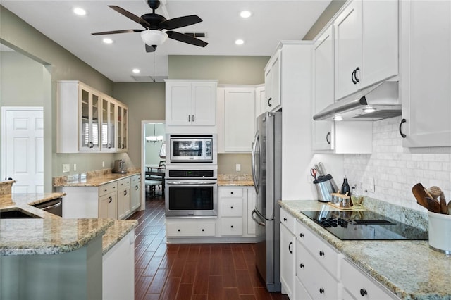 kitchen featuring light stone counters, white cabinetry, dark hardwood / wood-style flooring, and appliances with stainless steel finishes