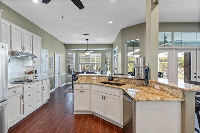 kitchen with pendant lighting, appliances with stainless steel finishes, sink, and white cabinets