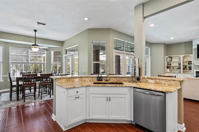 kitchen with sink, light stone counters, white cabinets, stainless steel dishwasher, and french doors