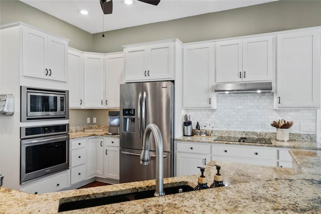 kitchen with ceiling fan, white cabinetry, backsplash, stainless steel appliances, and light stone counters