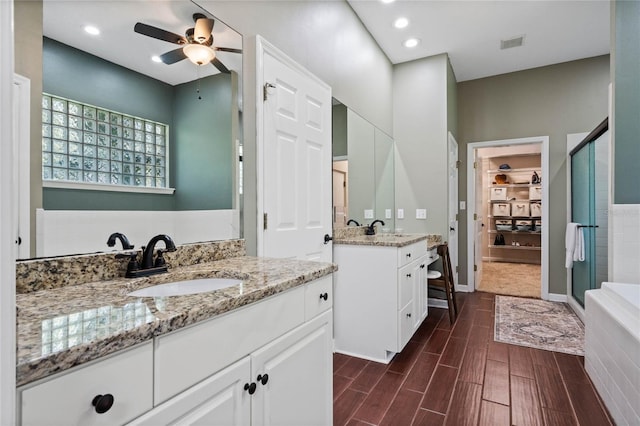 bathroom with vanity, ceiling fan, and a shower with shower door