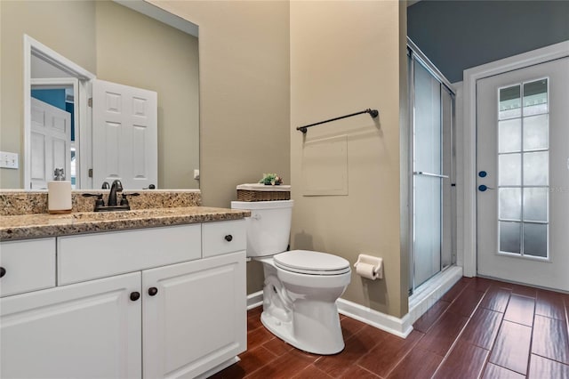 bathroom with vanity, toilet, and a shower with shower door