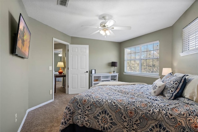 carpeted bedroom with ceiling fan and a textured ceiling