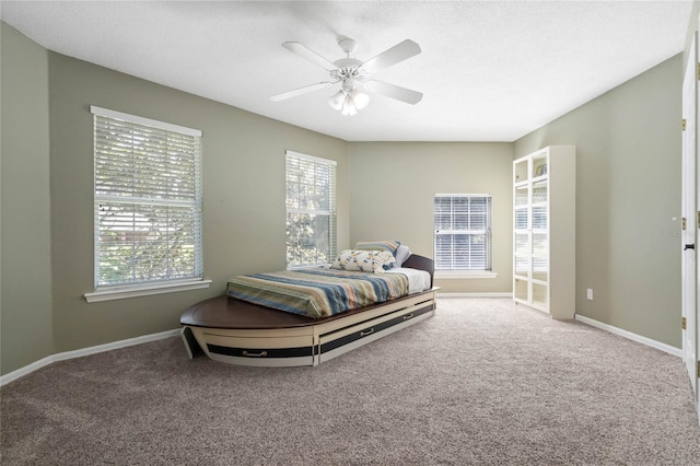 bedroom featuring multiple windows, carpet floors, a textured ceiling, and ceiling fan