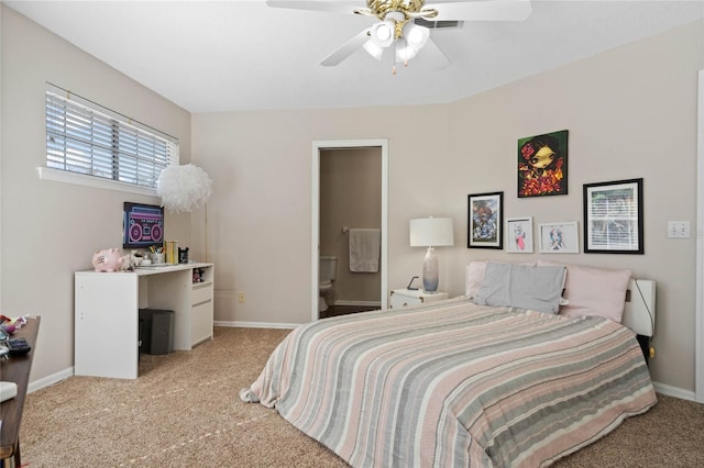 carpeted bedroom with ceiling fan and ensuite bath