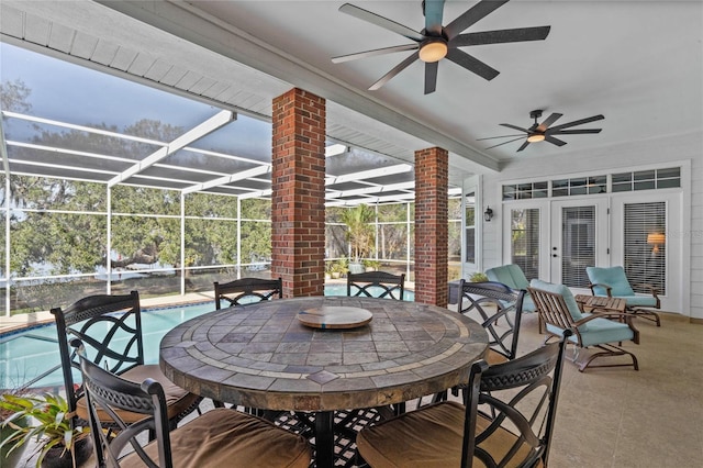 view of patio featuring ceiling fan and glass enclosure