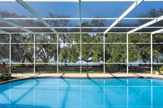 view of swimming pool featuring glass enclosure