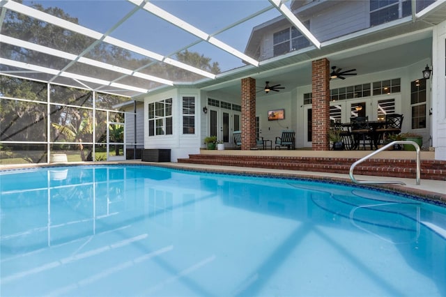 view of swimming pool featuring a patio, french doors, ceiling fan, and glass enclosure