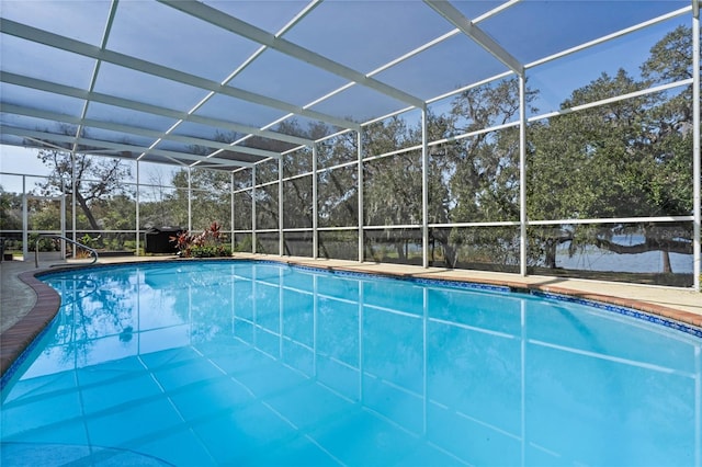 view of swimming pool with a water view and glass enclosure