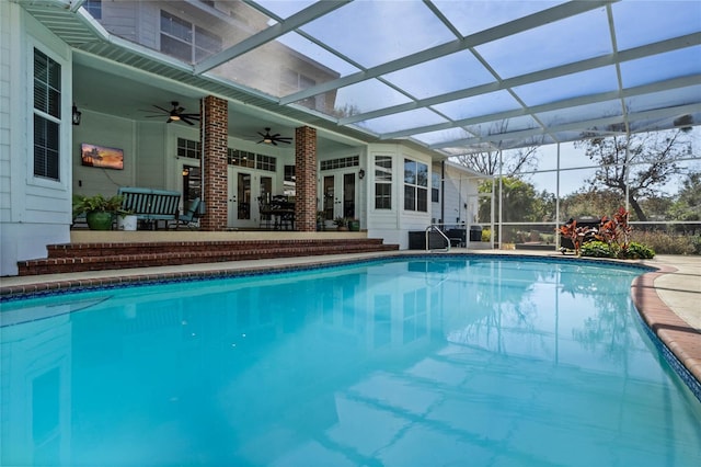 view of swimming pool featuring a patio area, french doors, ceiling fan, and glass enclosure